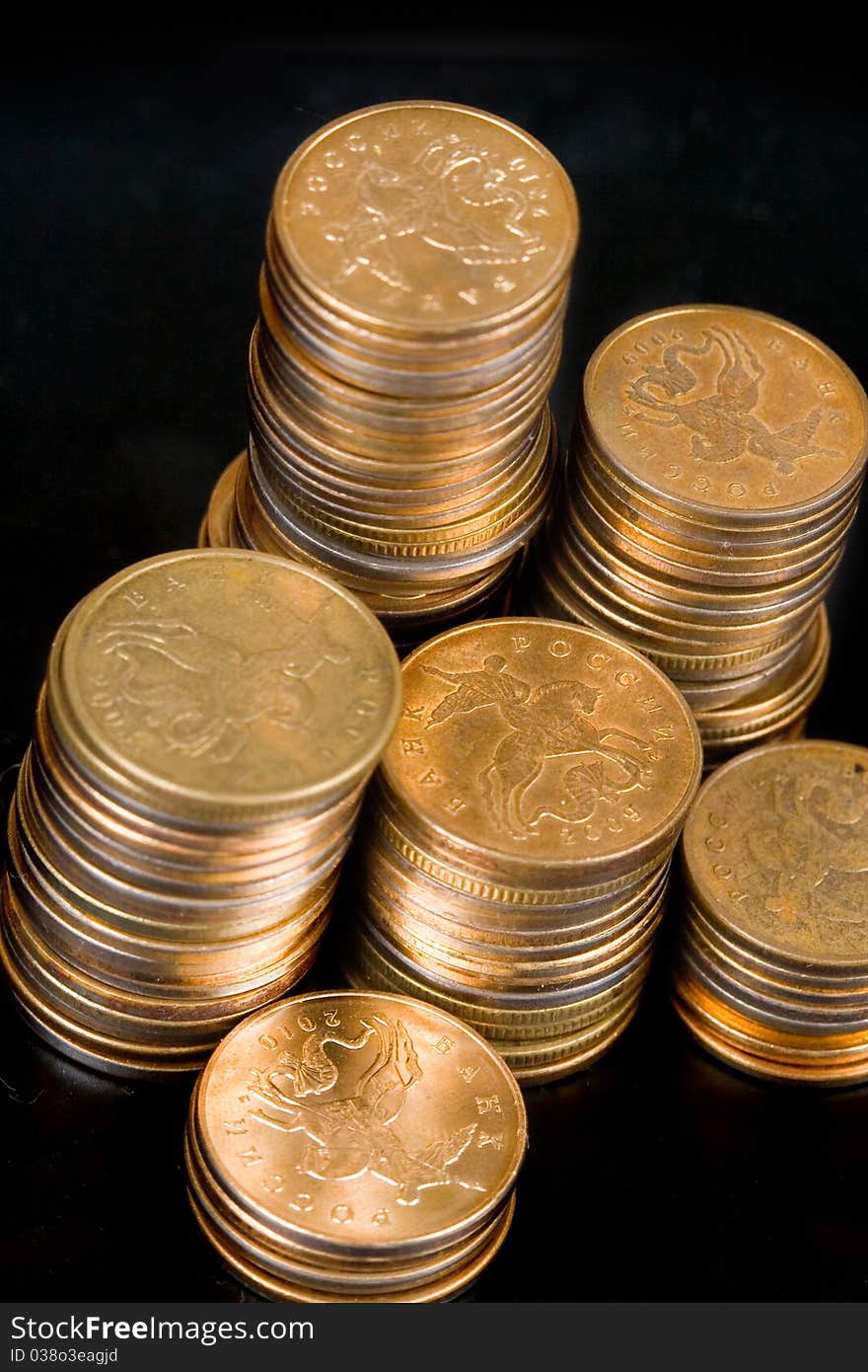 Piles of gold coins on a black background