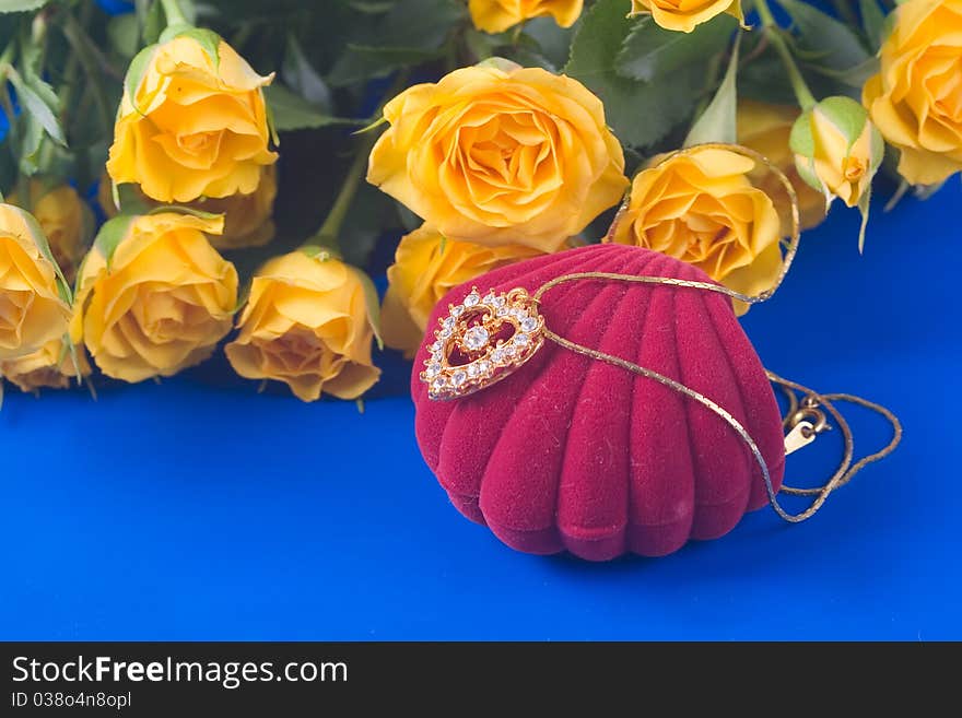 Beautiful yellow roses and golden heart on a blue background. Beautiful yellow roses and golden heart on a blue background