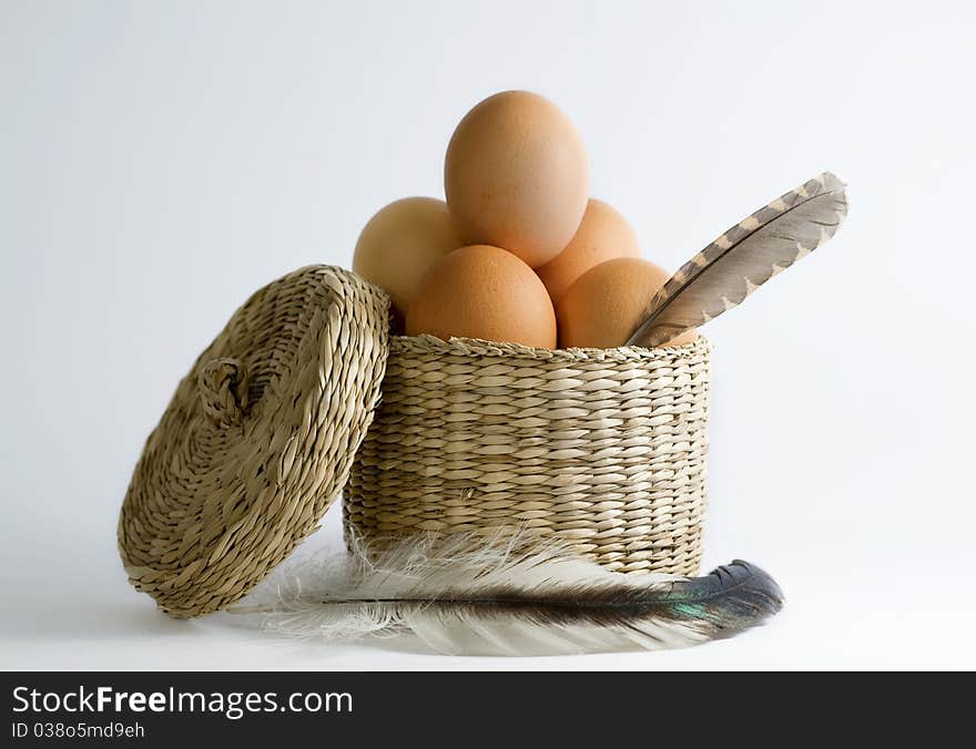 Eggs in basket with feathers