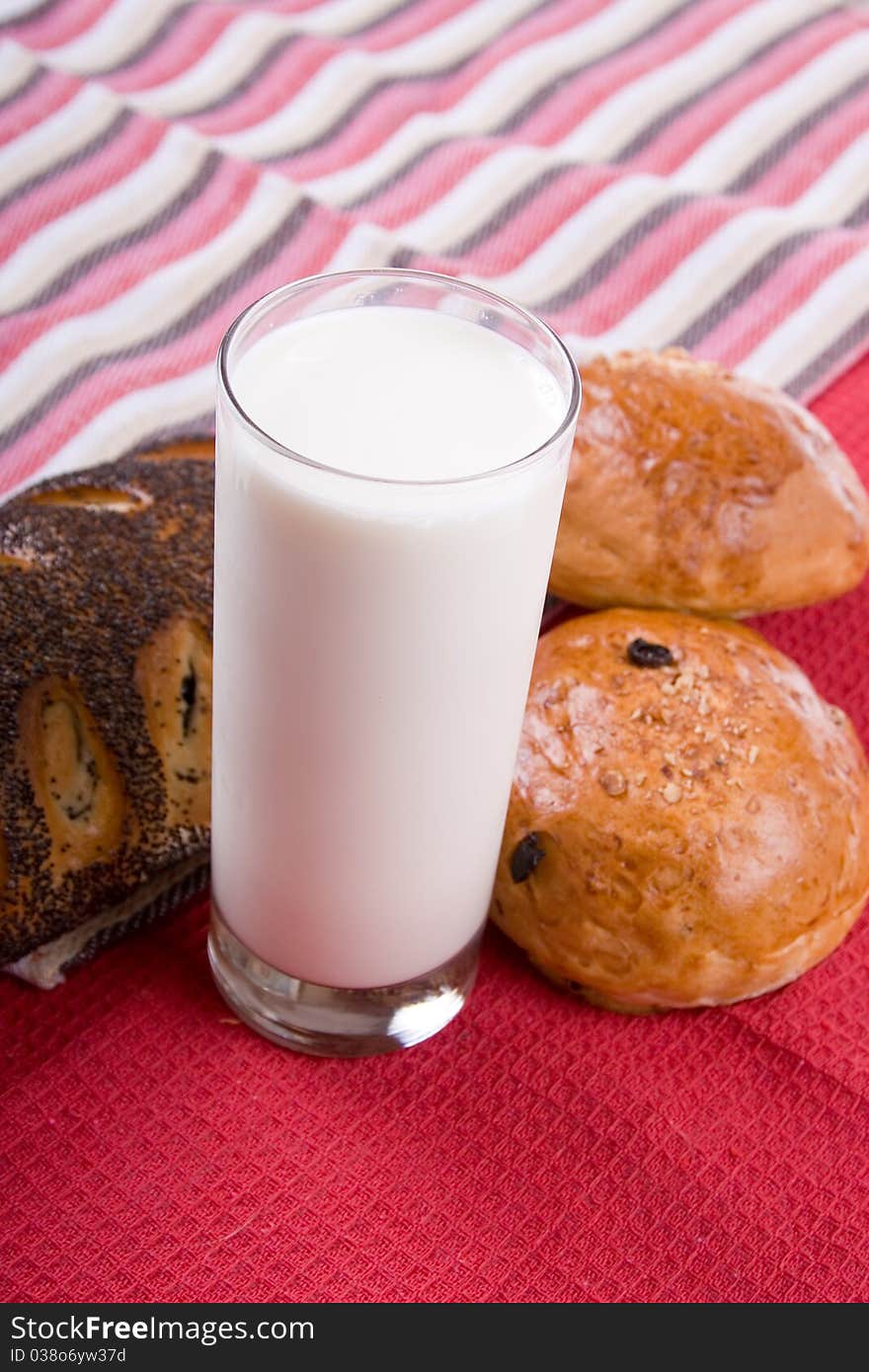 Fresh bread with glass of milk on a red background