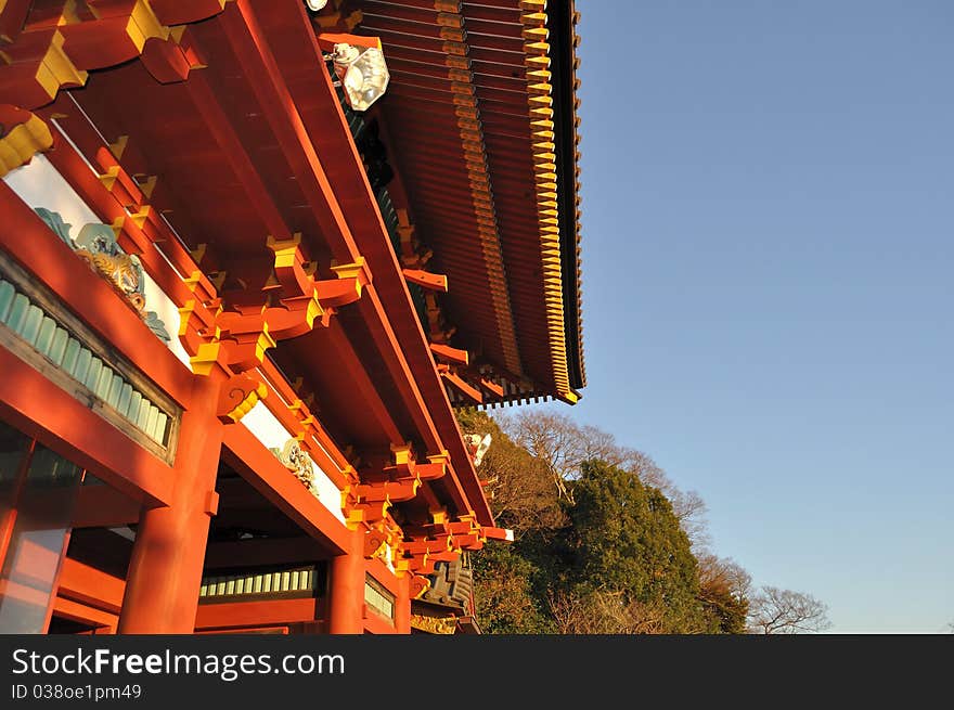 An upward shot of a Japanese temple with red pillars and roof, taken in the late afternoon. An upward shot of a Japanese temple with red pillars and roof, taken in the late afternoon.