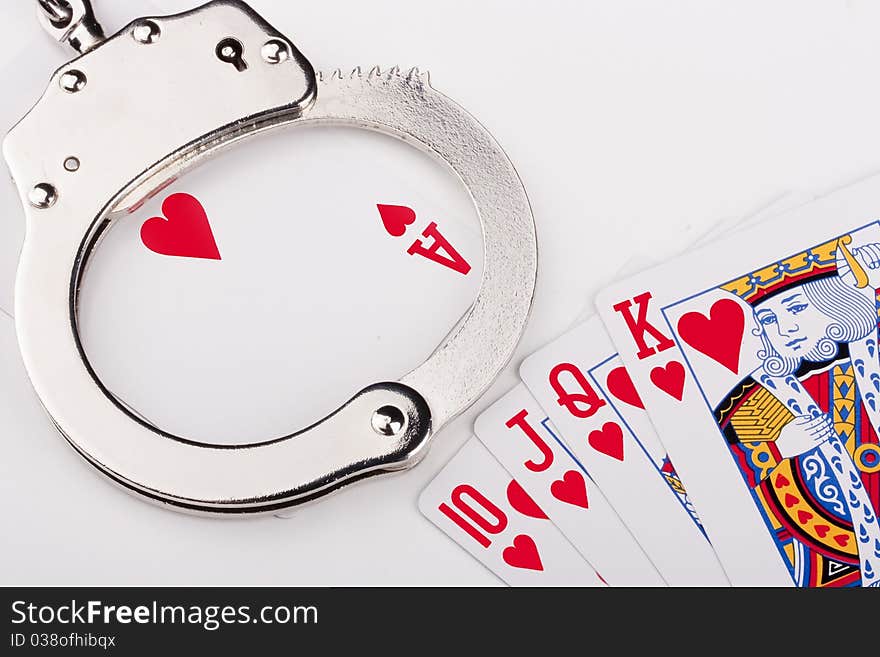 Handcuffs with things gaming - playing cards on a white background.