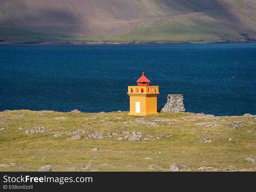 Lighthouse Faskrudsfjordur yellow in the fjord in Iceland