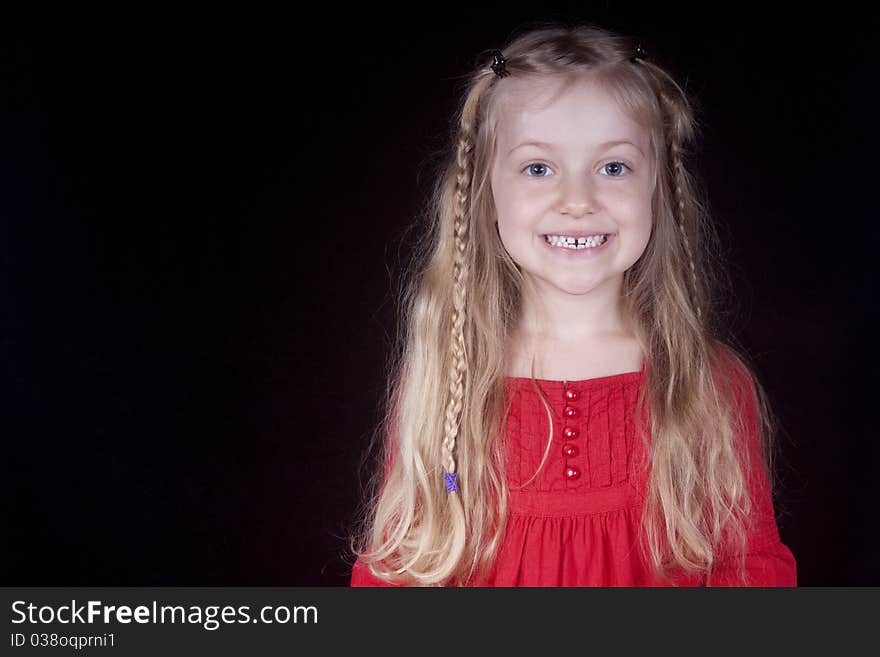 A little blond girl in red smiling. A little blond girl in red smiling