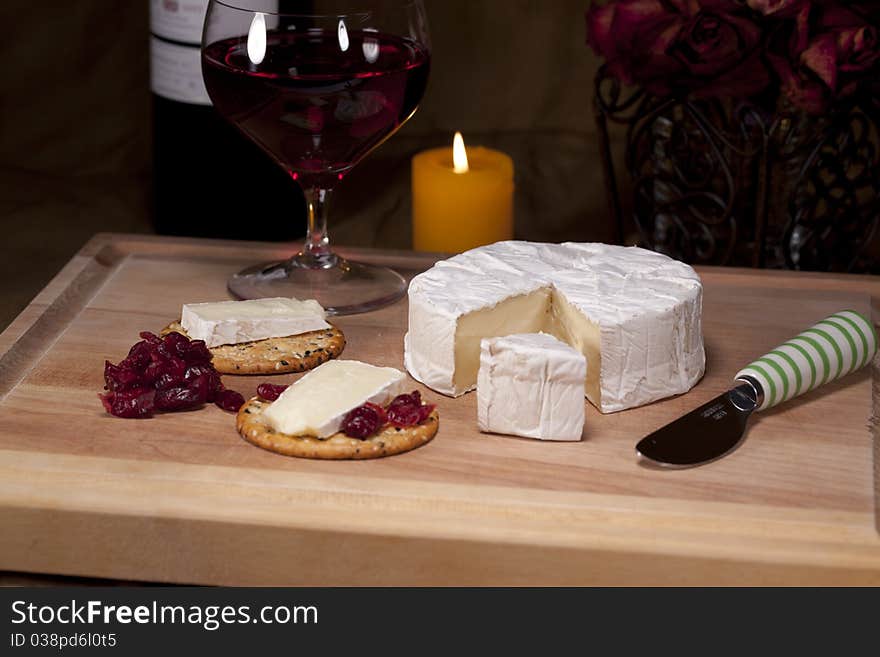 Cheese on wooden board with crackers a glass of redwine. Cheese on wooden board with crackers a glass of redwine