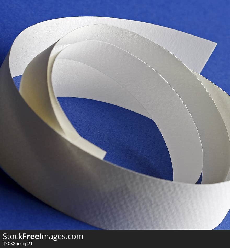 Round white textured paper strips on blue background