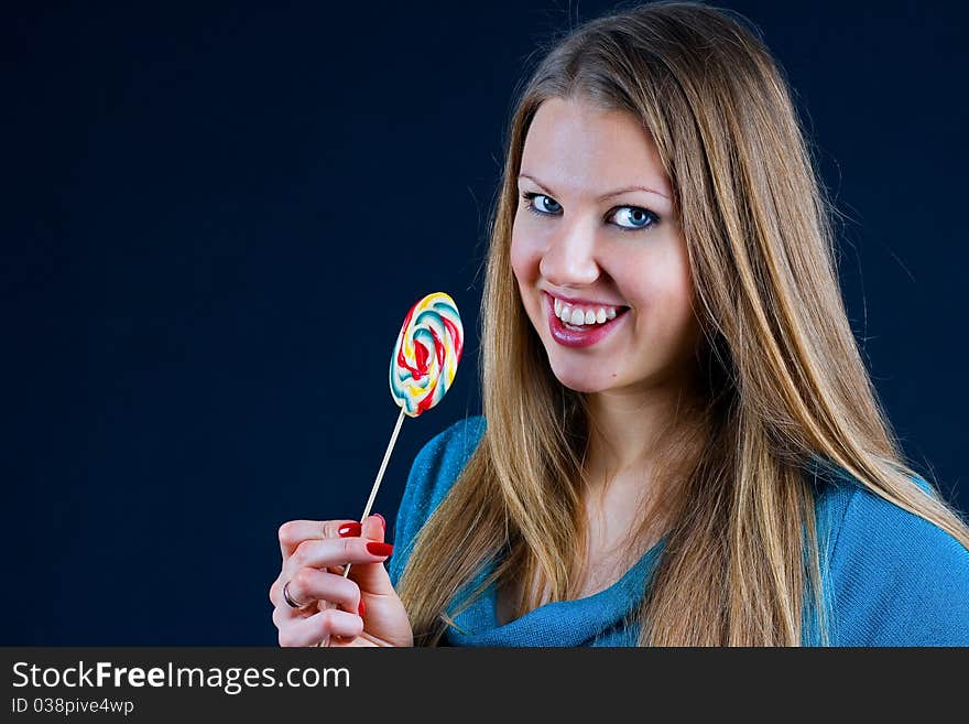 Beautiful girl holding a candy on a stick in his hand