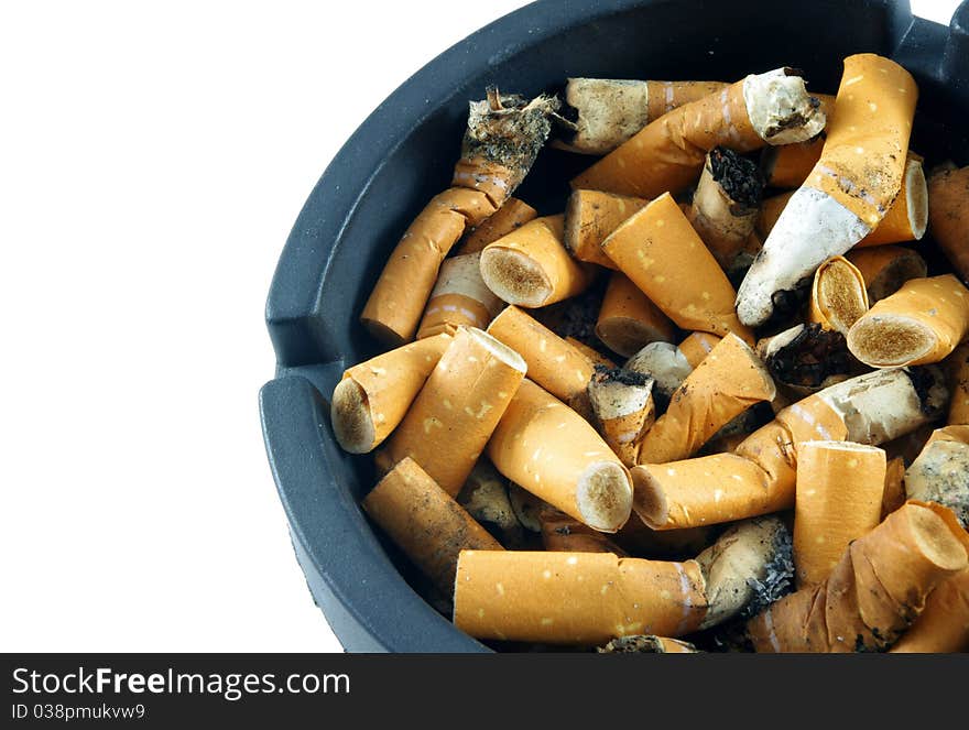 Cigarette butts in ashtray over white surface