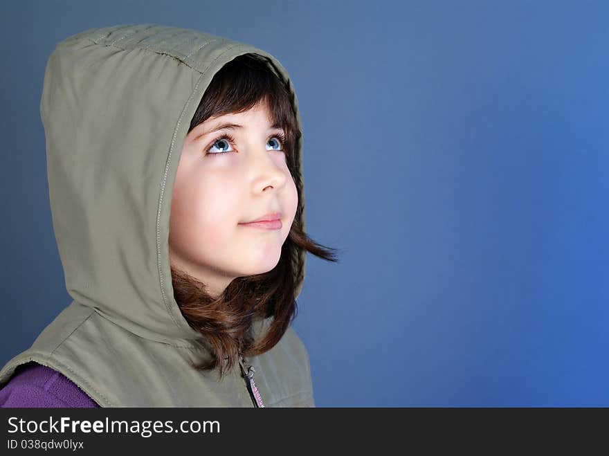 Smiling little child looking up at copyspace isolated on blue background