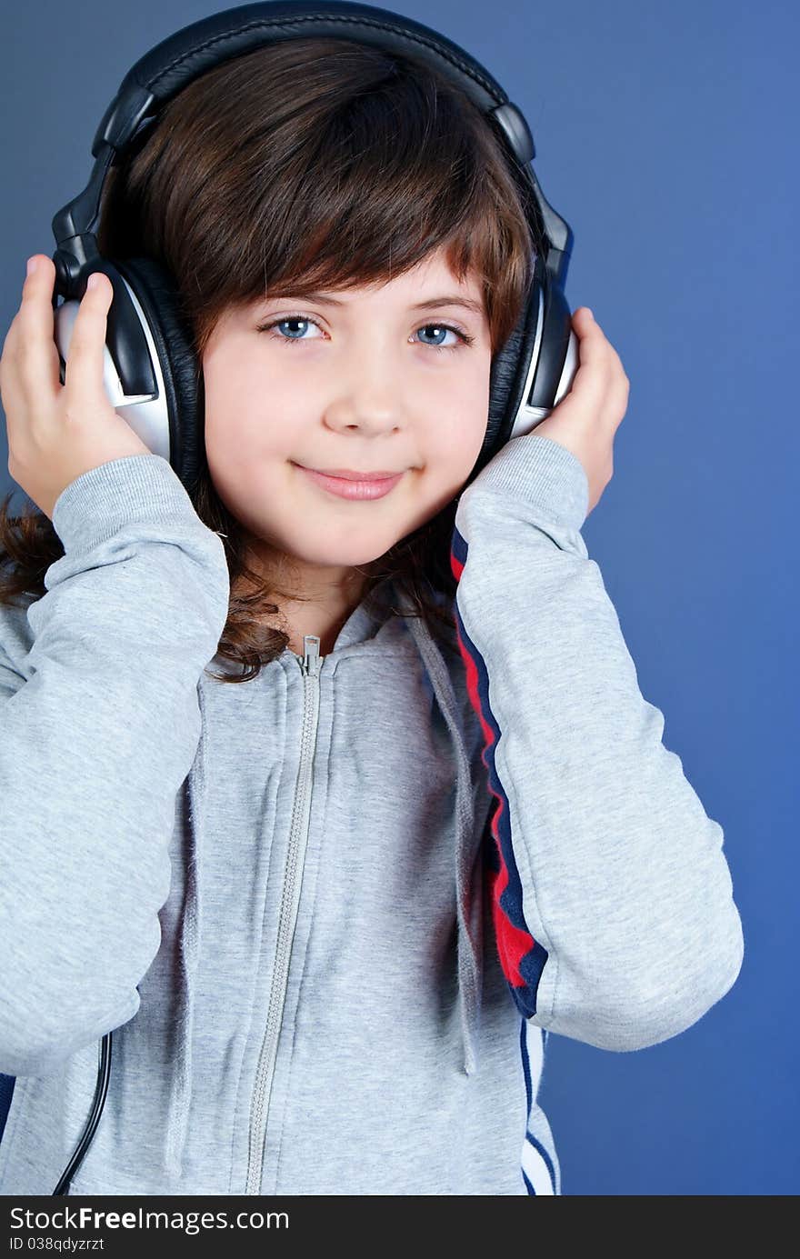 Cute little girl with earphones isolated on blue