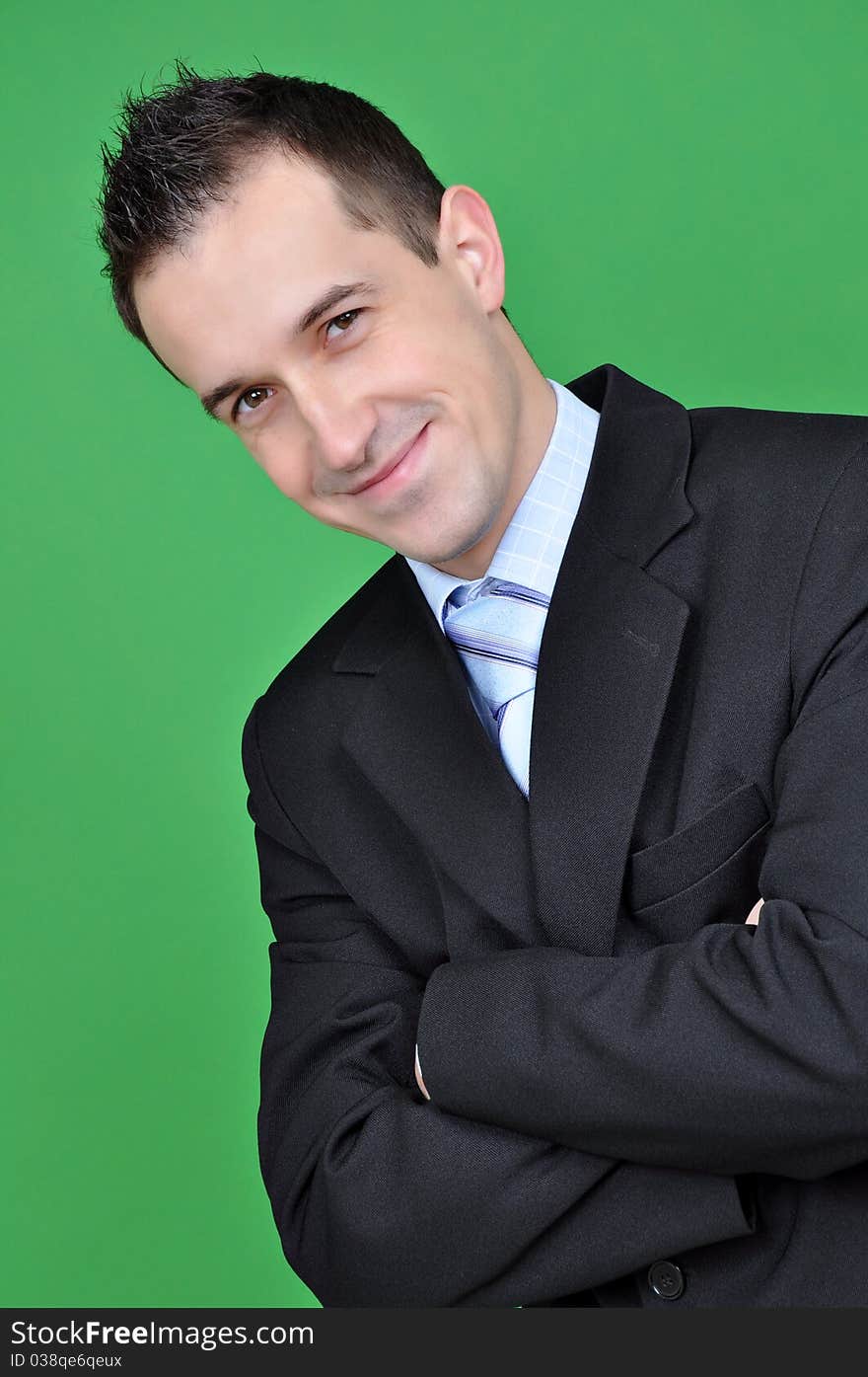 Young business man isolated on green background