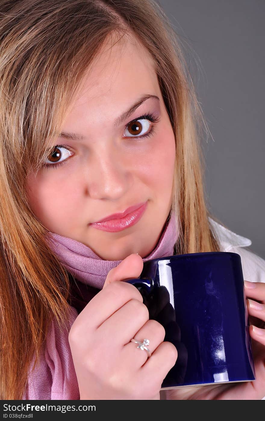 Beautiful blond woman woth tea cup on grey background