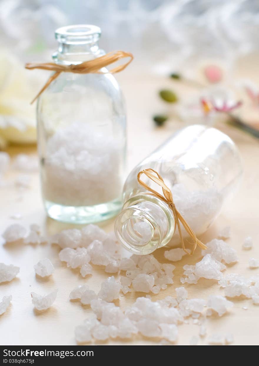 Jar of sea salt and flower on wood