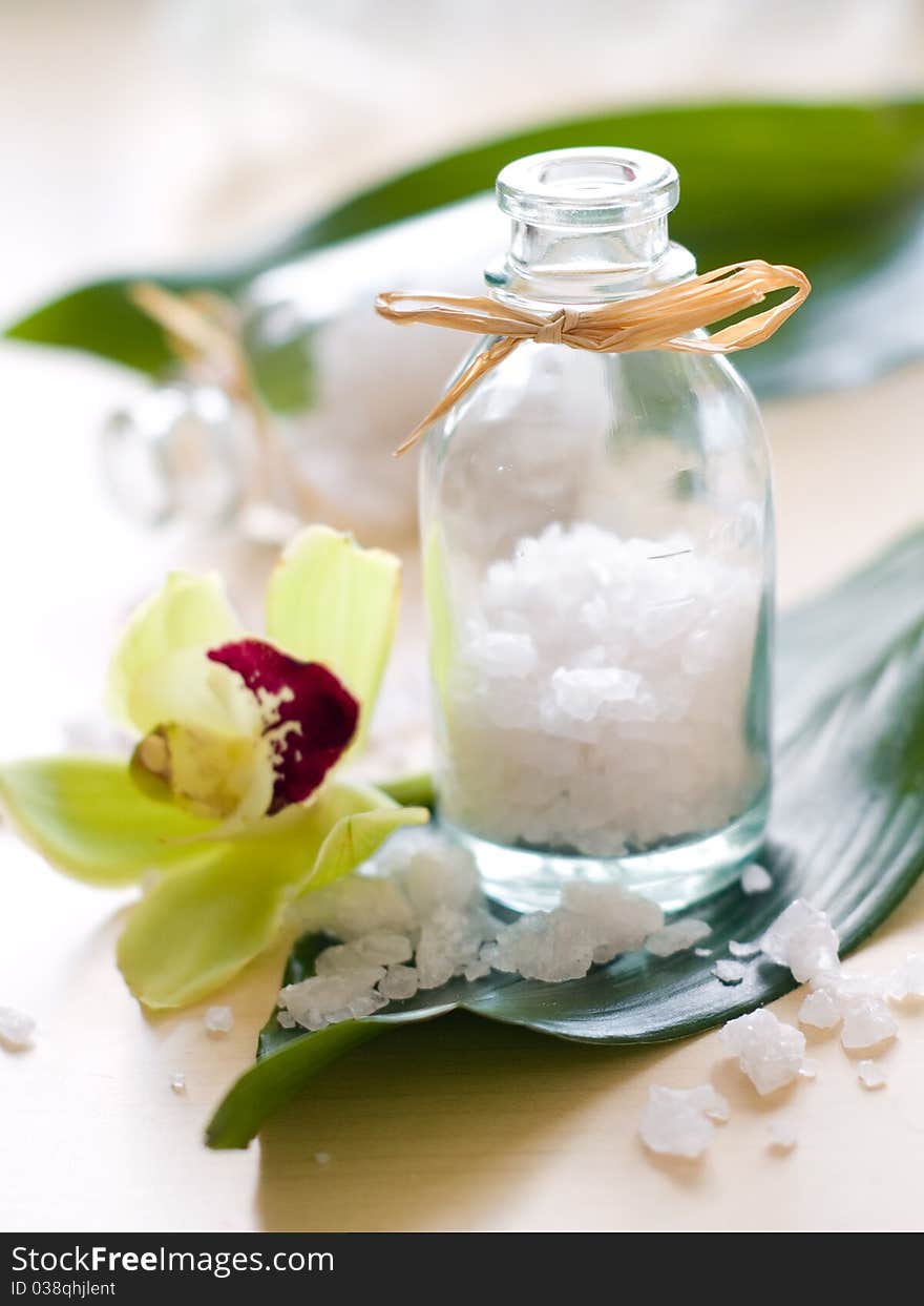 Jar of sea salt and flower on wood