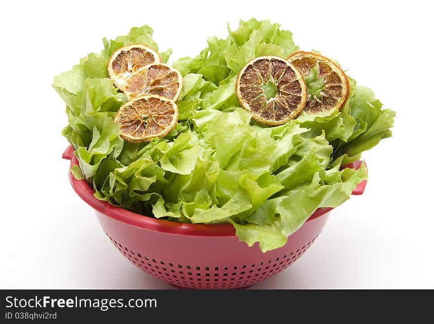 Cut lemon on endives salad in the kitchen sieve