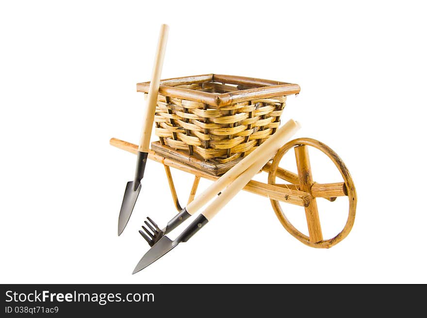 The cart with rake, shovel and spade isolated over white. The cart with rake, shovel and spade isolated over white