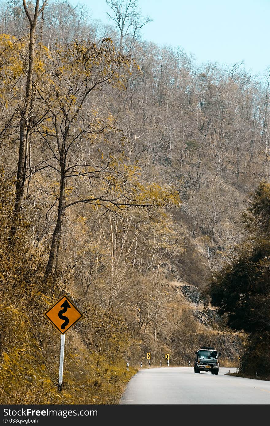 Road through the mountain in winter with traffic sign. Road through the mountain in winter with traffic sign