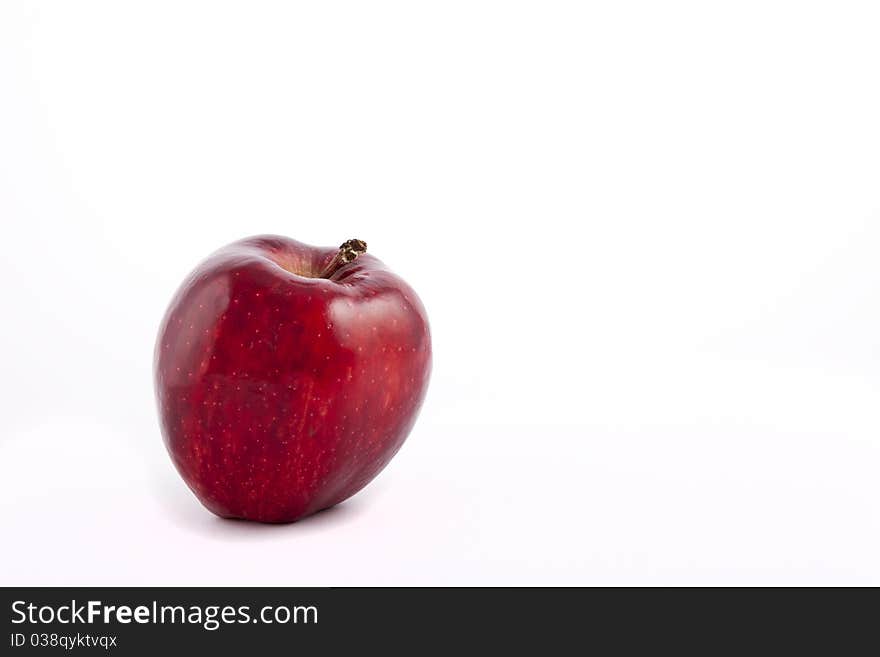 Yellow apple with brown spots on a white background