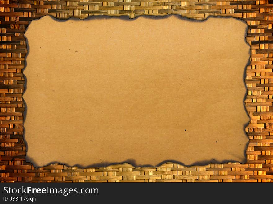 Paper with burned edges on weave bamboo background