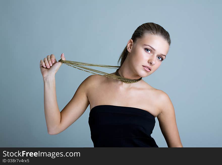 Beautiful woman pulling gold necklace. Beautiful woman pulling gold necklace