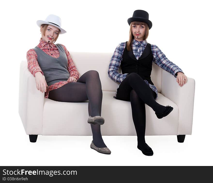 Two girls on the couch with a mustache painted on a white background