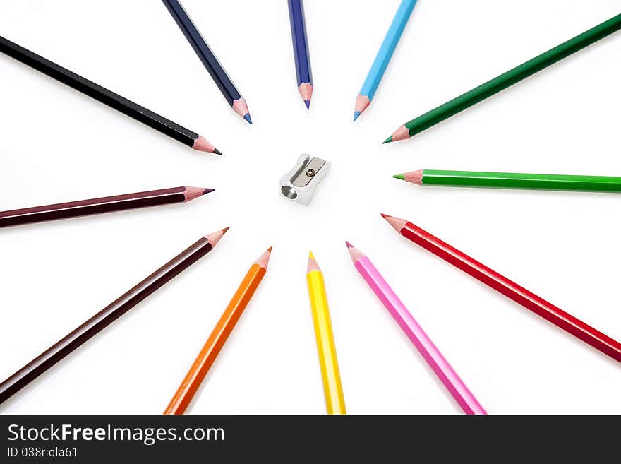 A group of colourful pencils surrounding a metal pencil sharpner. A group of colourful pencils surrounding a metal pencil sharpner.