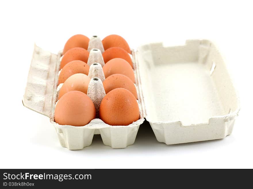 Ten chicken eggs in the box on white