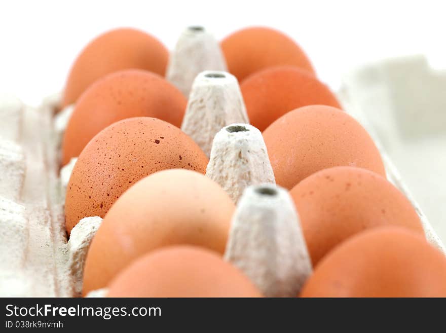 Chicken eggs in a box on white