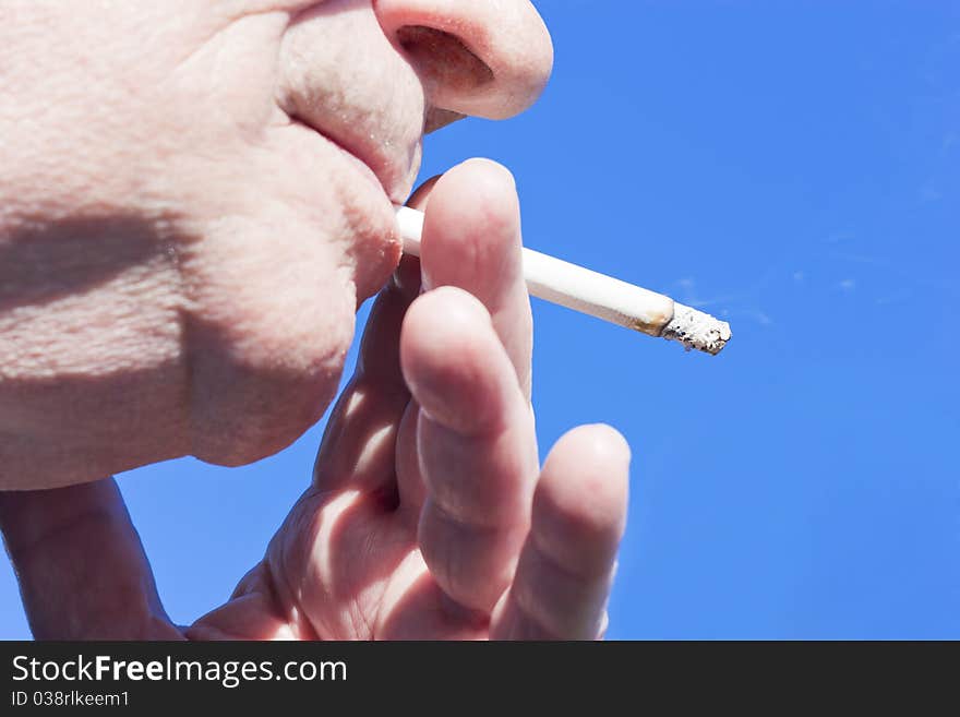 Handheld cigarette on blue background. Handheld cigarette on blue background