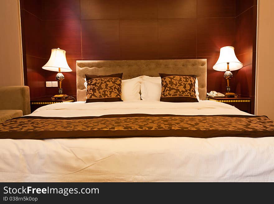 Hotel bedroom with kingsized bed and lamps.