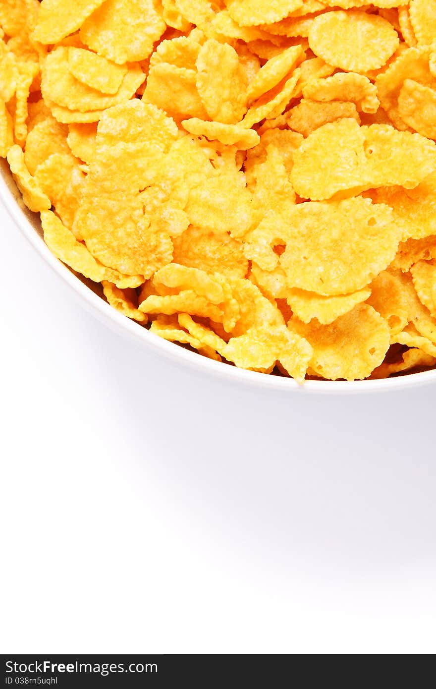 Bowl of cornflakes over white. Top view