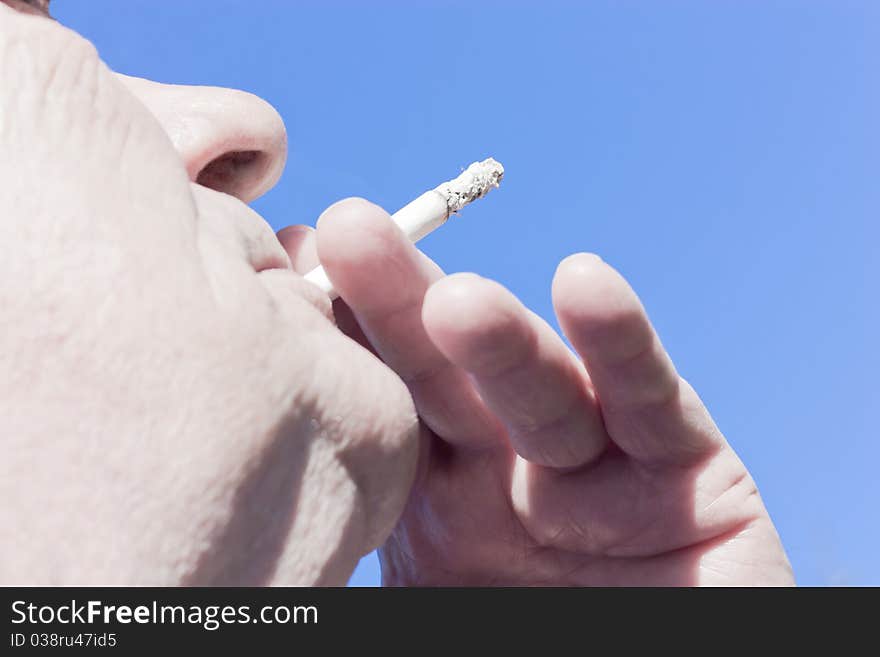 A cigarette held by a smoker addict