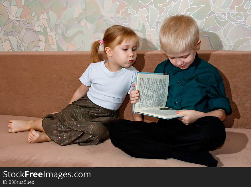 Brother and sister read a book together. Brother and sister read a book together