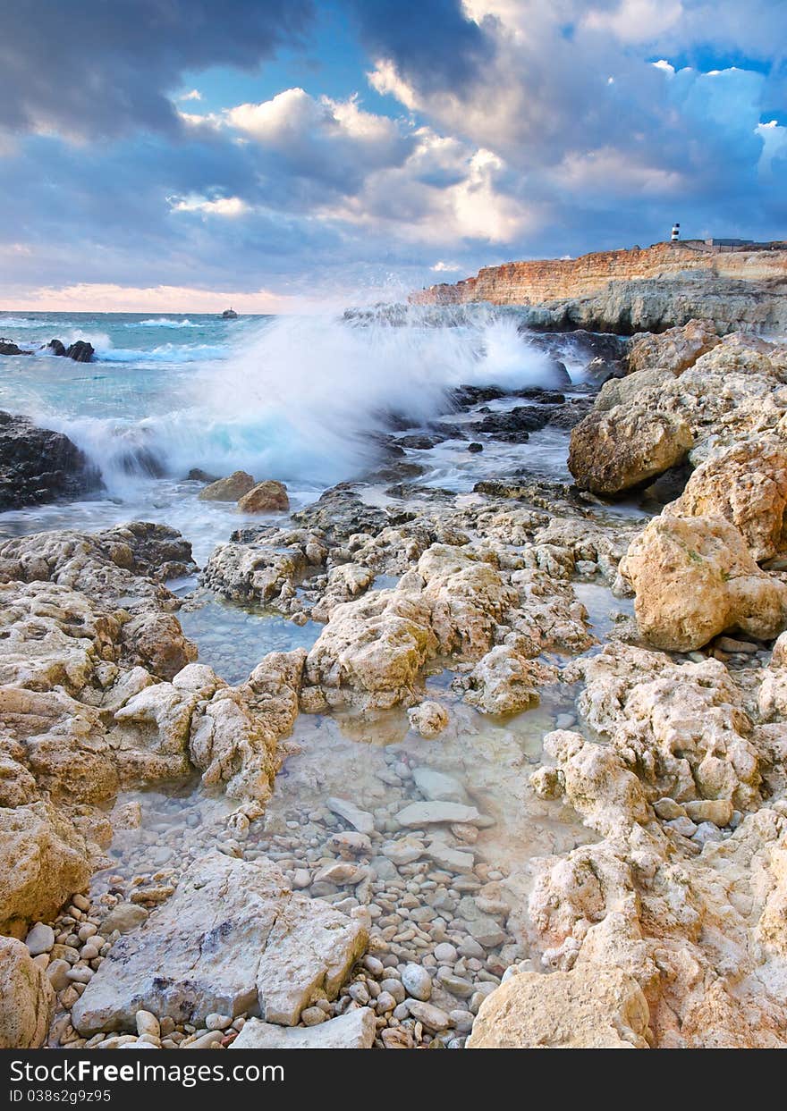 Seashore with stone on background bright sky during sundown. Natural composition