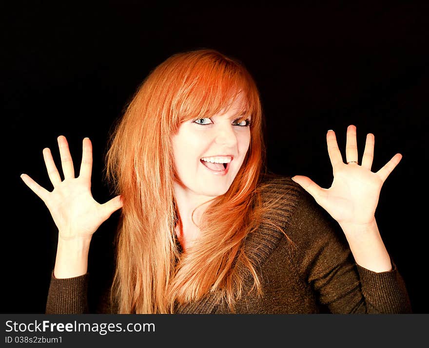 Young red-haired girl smiling on a dark background