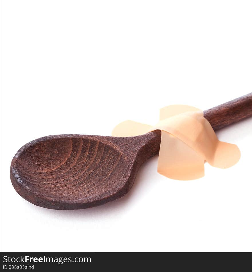 Wooden spoon with plaster isolated on white background. Wooden spoon with plaster isolated on white background