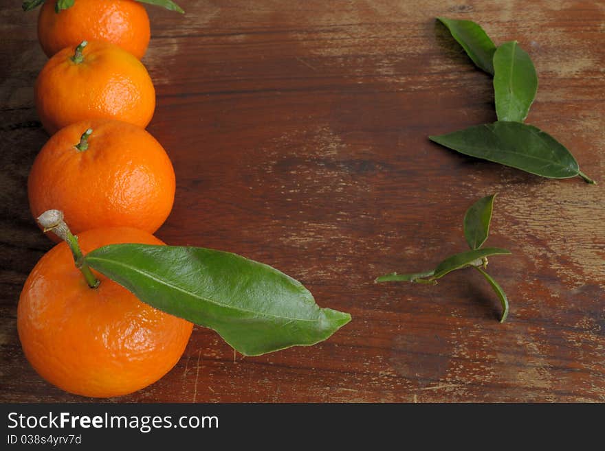 Mandarins and the leaves on a wooden table. Mandarins and the leaves on a wooden table