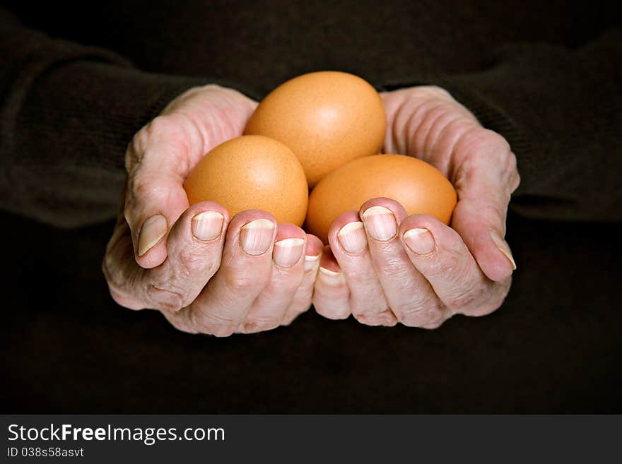 Three eggs in senior woman's hands