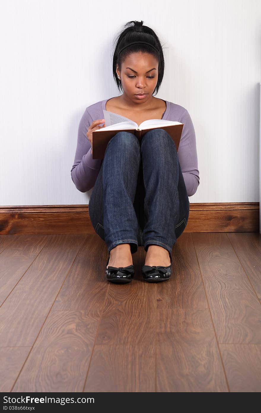 Young black girl concentrating hard reading a book