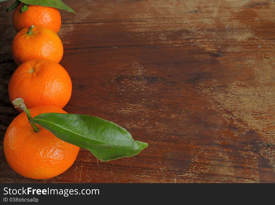 Mandarins and the leaves on a wooden table. Mandarins and the leaves on a wooden table