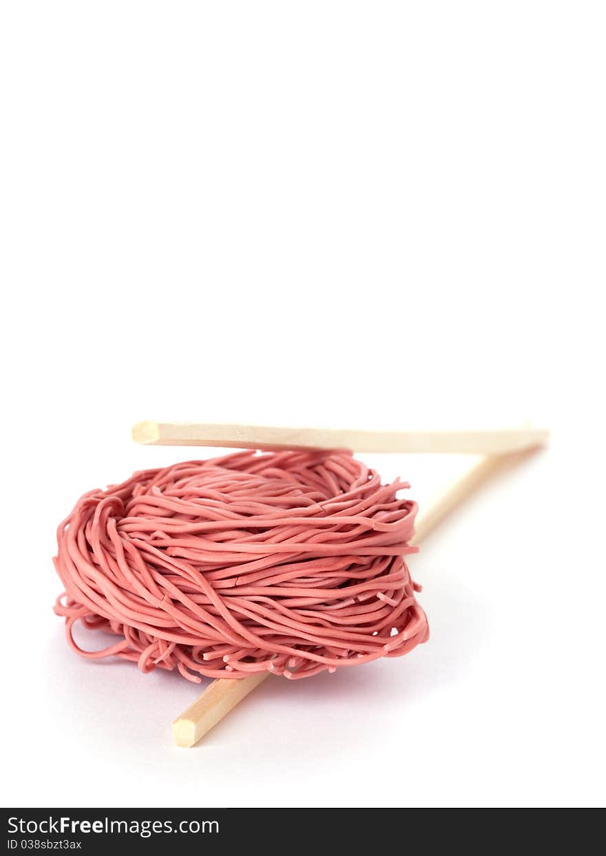 Red noodles and chopsticks isolated on white background