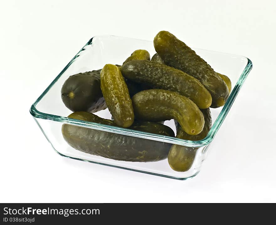 Pickled cucumbers in glass container on white background