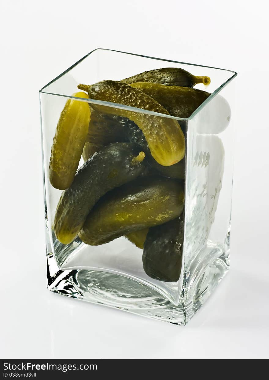 Pickled cucumbers in glass container on white background