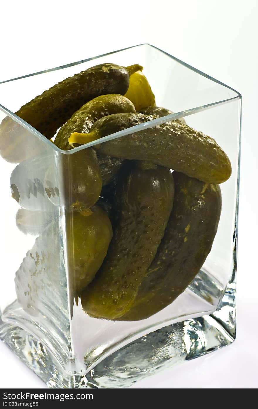 Pickled cucumbers in glass container on white background