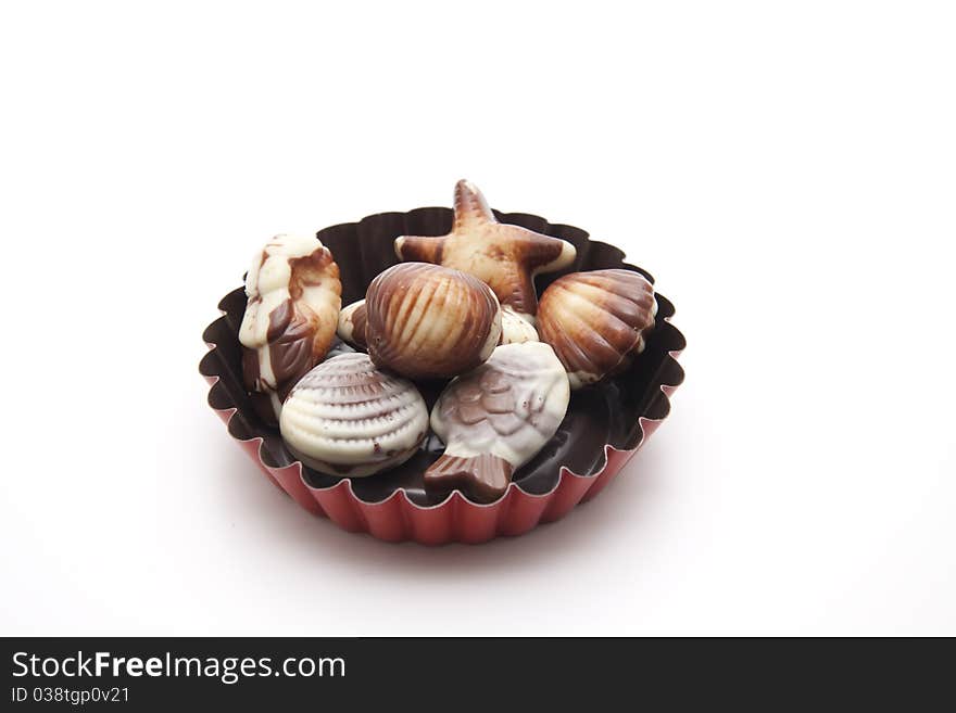 Mussel chocolates onto white background