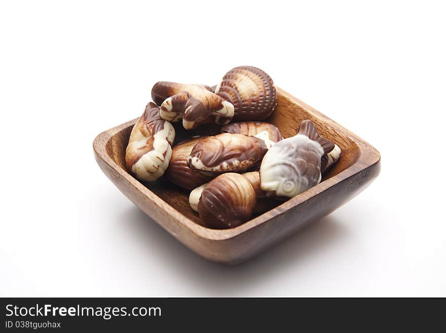 Mussel chocolates in the wood bowl. Mussel chocolates in the wood bowl