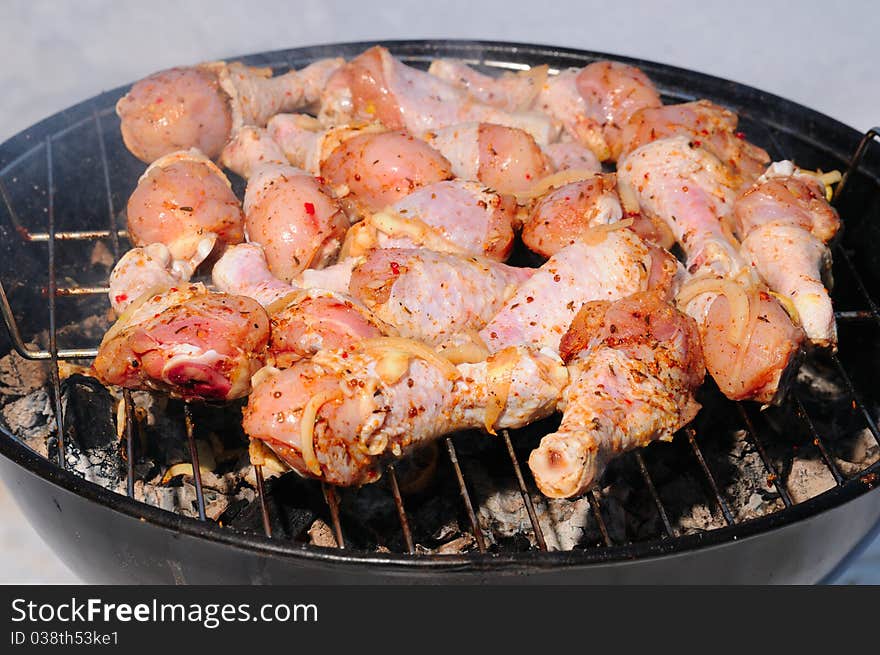 Preparation of a chicken drumstick on a barbecue