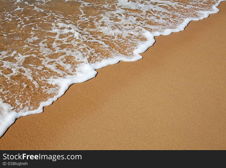 Sandy beach and water wave background