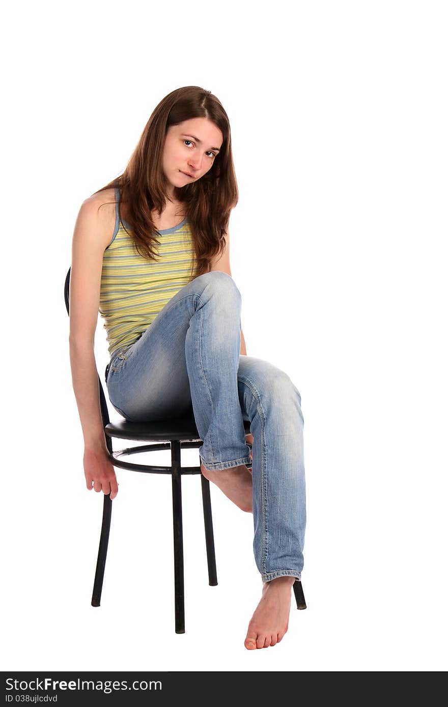 Girl in green stripy top sit on stool. Isolated on white.