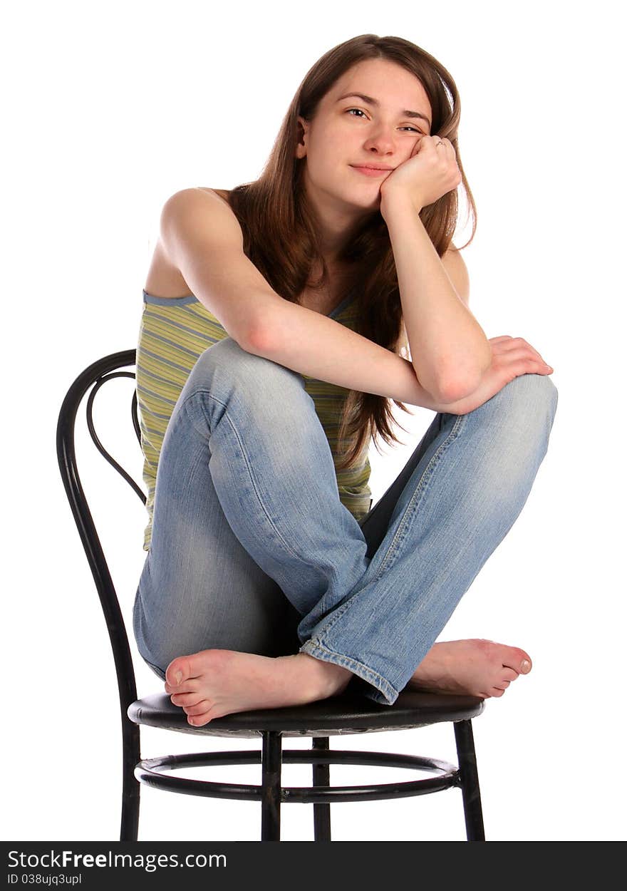 Girl in green stripy top sit on stool dreaming. Isolated on white.